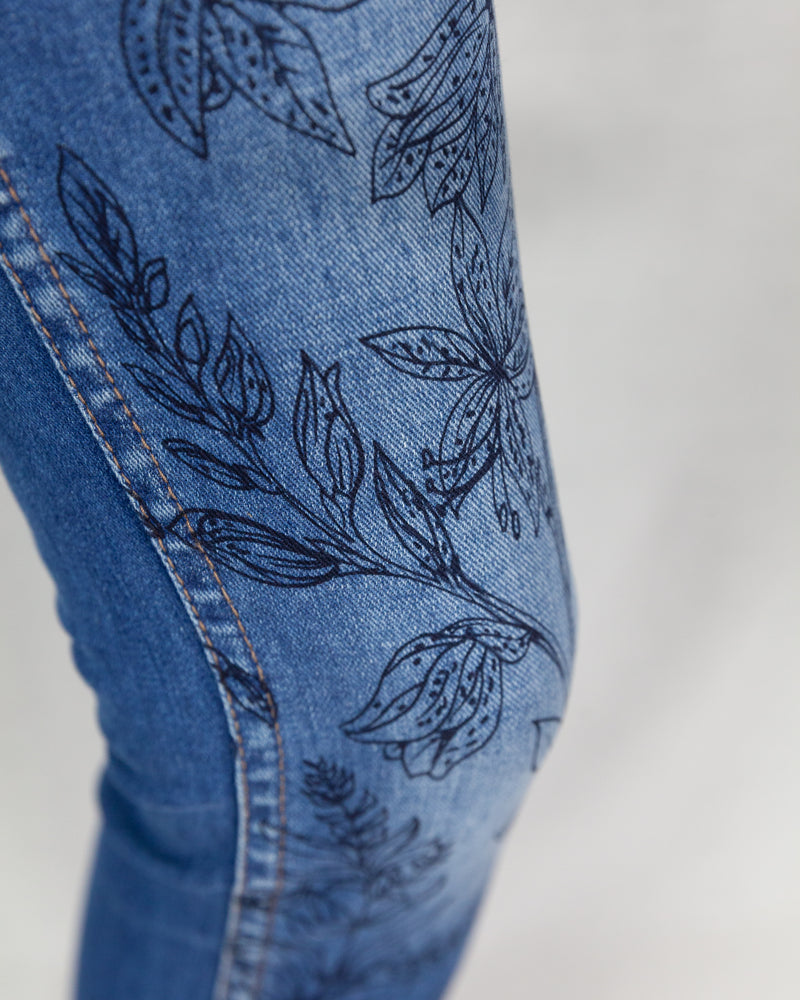 Mid-rise denim jeans with a floral illustration and frayed ankle hem