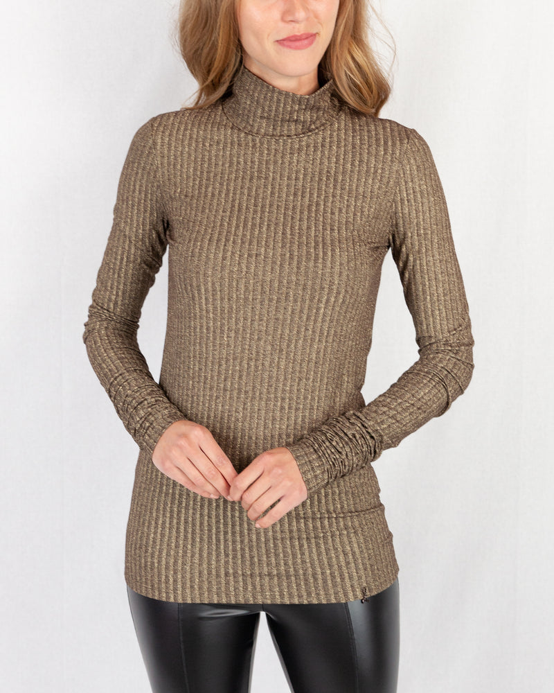 Gold Lurex Ribbed Turtle Neck. Slim Fitting With Extra Long Slim Sleeve. Below Hip Length With A Fly Charm Logo On Hem.