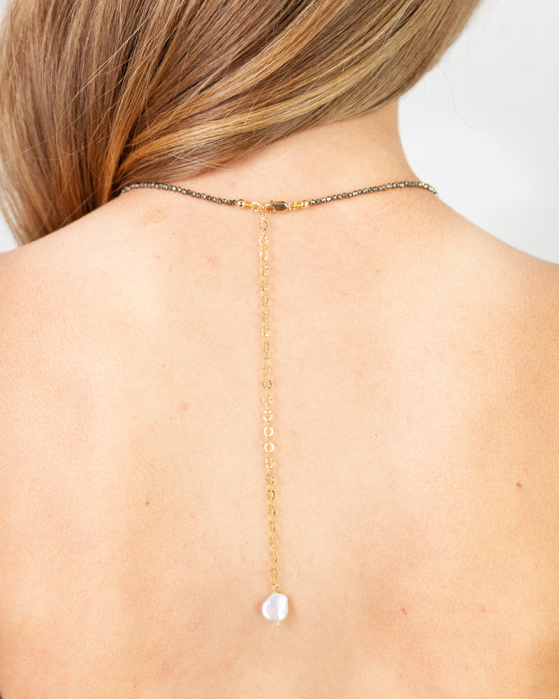 Gold choker necklace with a star detail cutout on a pave disc pendant
