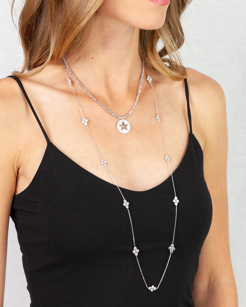 Silver choker necklace with a star detail cutout on a pave disc pendant